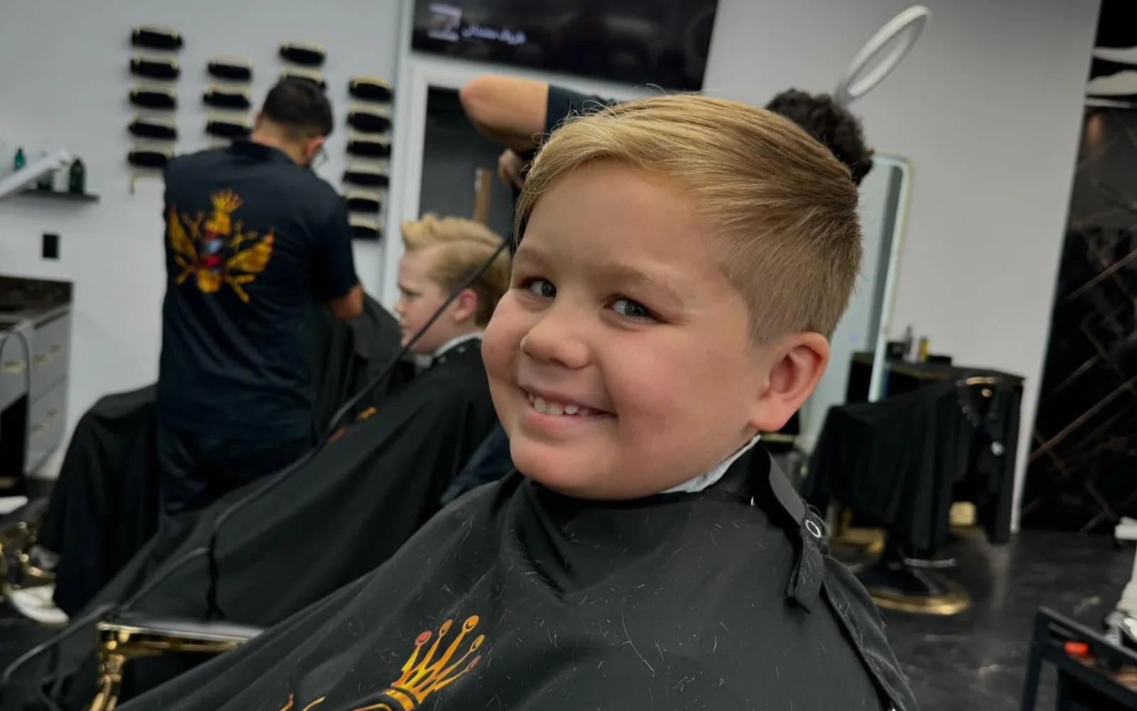 Barber giving a kid a haircut at S Blends